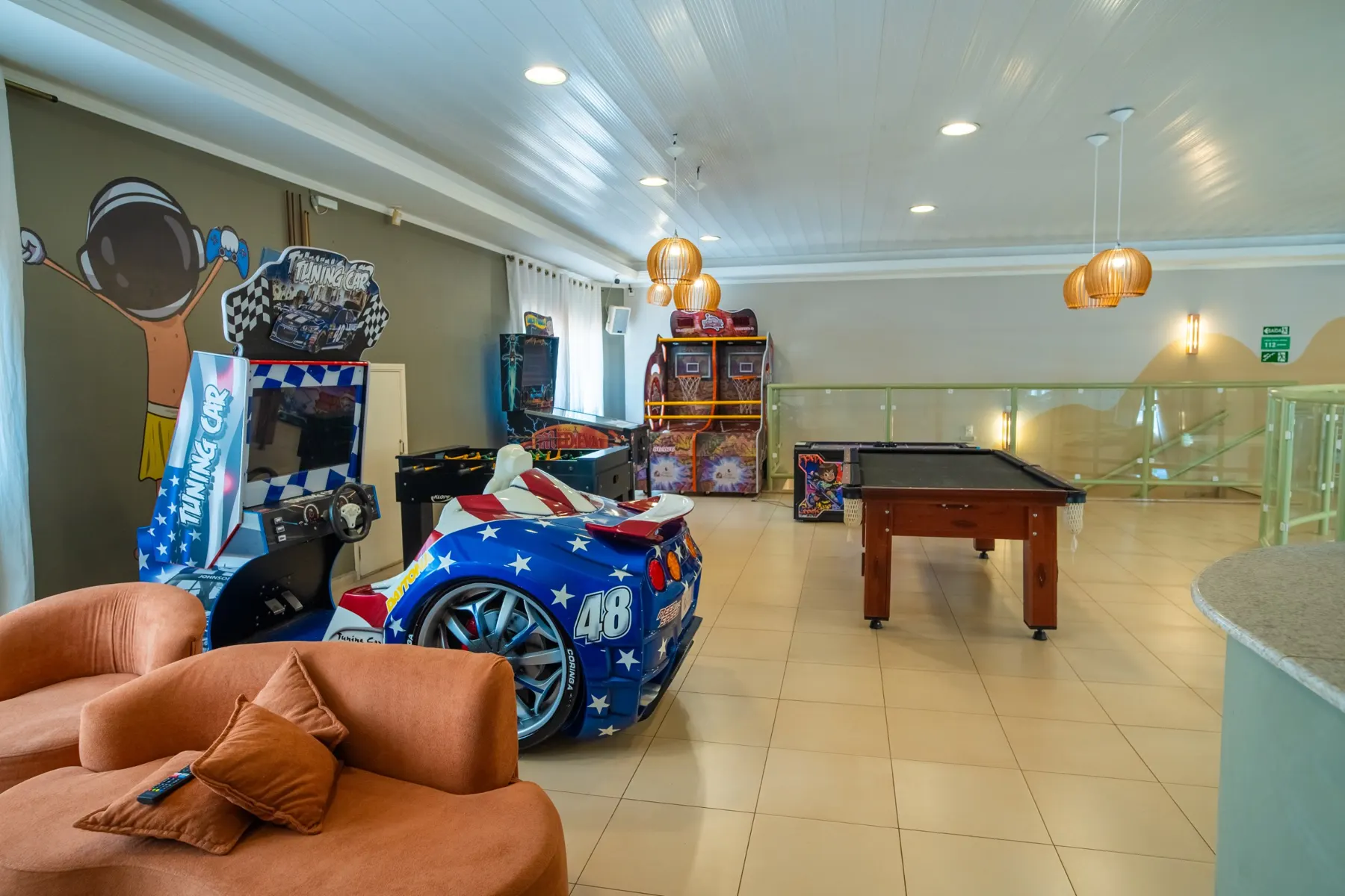 Sala de games com simulador de corrida, basquete e sinuca
